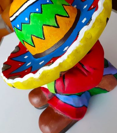 Bunte, handbemalte Figur mit traditionellem Sombrero und farbenfrohem Outfit.