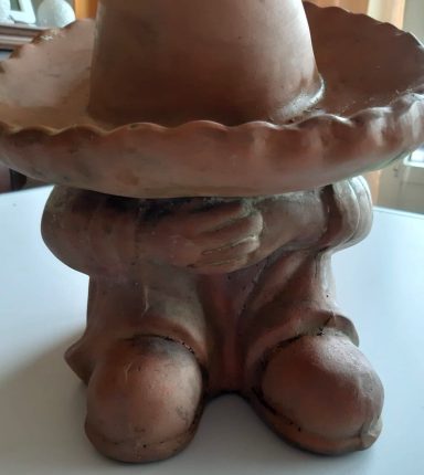 Tontopf in Form einer Figur mit großem Sombrero und verstecktem Gesicht.