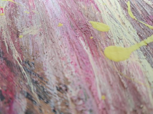 Bunte Textur mit lila, rosa und gelben Farbspritzern auf einer strukturierten Oberfläche.