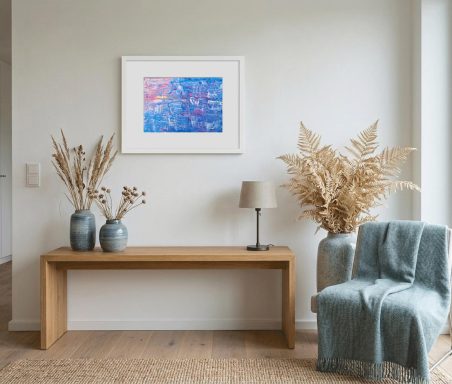 Holztisch mit Vasen, Trockenblumen, Lampe und Stuhl vor einer bunten Wandkunst.