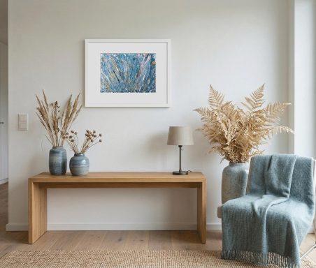 Heller Raum mit einem Holzsideboard, Vasen, einer Lampe, einem Stuhl und Kunstwerk an der Wand.