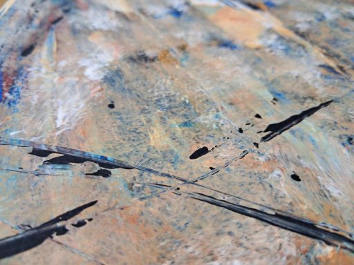 Abstrakte Farbmischung mit blauen und schwarzen Akzenten auf beige-braunem Hintergrund.