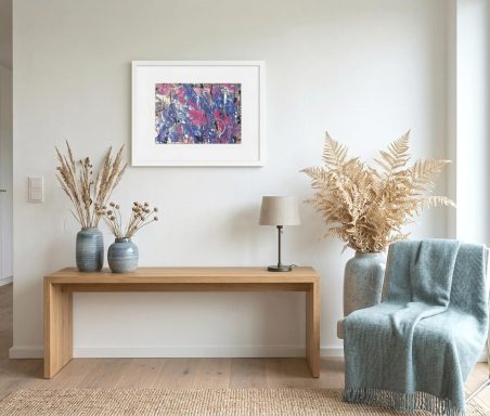 Holztisch mit Pflanzen, Lampe und einem Sessel, dekoriert mit einem bunten Kunstwerk an der Wand.
